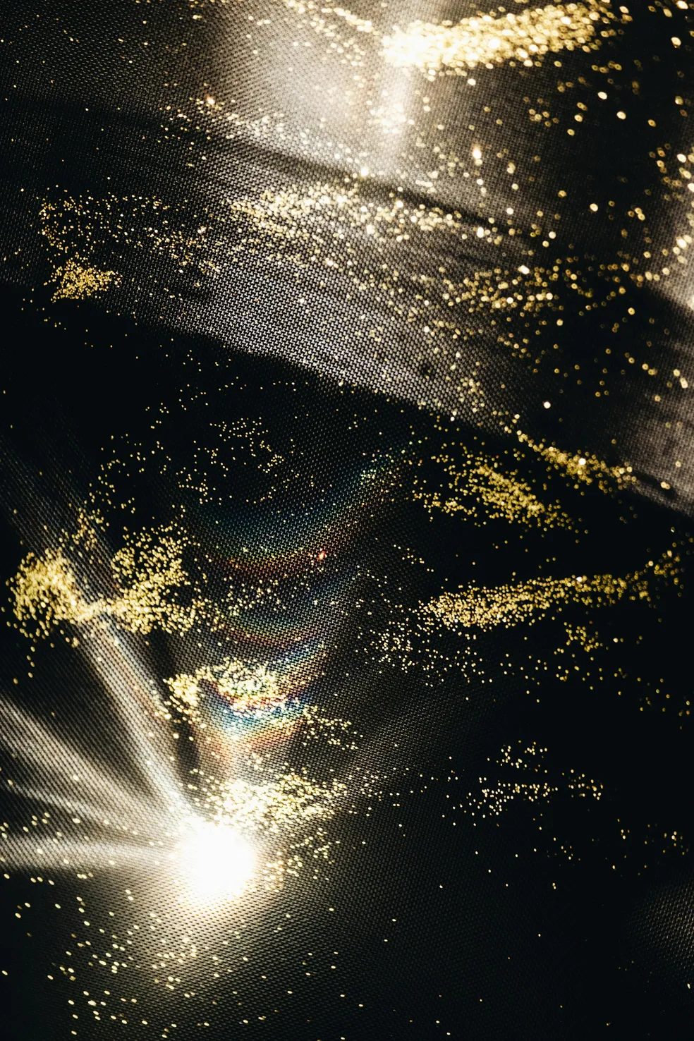 Close-up of shimmering gold glitter on black fabric